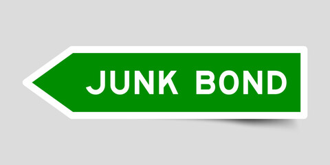 Green color arrow shape sticker label with word junk bond on gray background