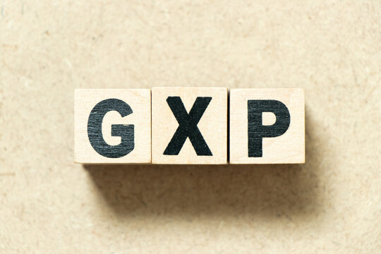 Alphabet letter block in word GXP on wood background