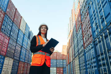 Woman engineer with Clip Folder in white helmet and vest working in container terminal port - obrazy, fototapety, plakaty