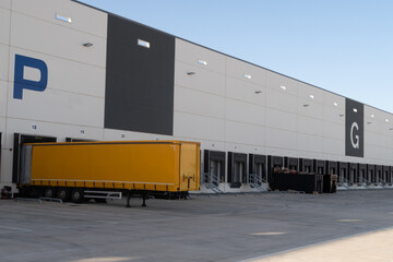 Vista de un camión trailer cargando en el muelle de una empresa logistica de distribucion de productos.
