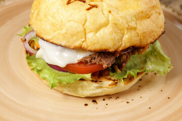 Juicy burger with chopped beef, cheese salad and tomato close-up. Selective focus