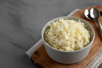 Homemade German Sauerkraut in a Bowl on a gray background, side view. Copy space.