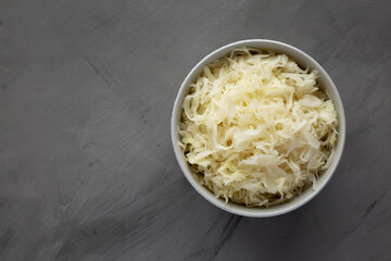 Homemade German Sauerkraut in a Bowl on a gray background, top view. Copy space.