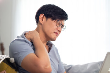 Office syndrome. Asian thai businessman suffering from shoulders neck and back pain after working...
