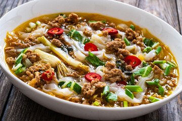 Yunnan rice noodle soup on wooden table