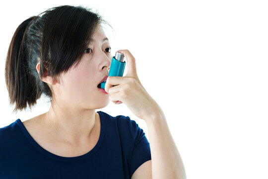 Young asian woman using asthma inhaler isolated on white background