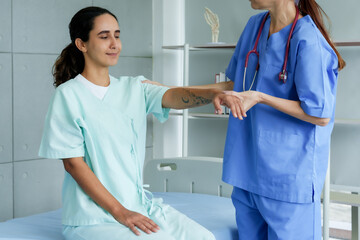 physical therapist anonymous Helping a temporarily paralyzed patient lift his arms back and forth...