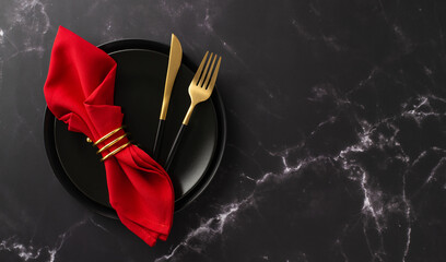 Christmas dinner at a restaurant. Top view of festive plates, exquisite gold flatware, red napkin with ring on luxurious black marble table with text space - Powered by Adobe