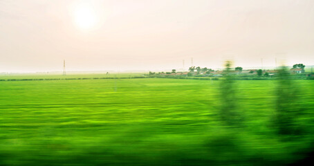 Blurred countryside farm from moving train window