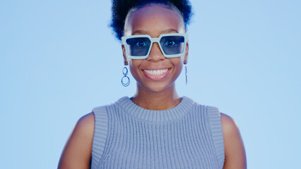 Portrait, sunglasses and smile, black woman in studio with cool, trendy summer fashion and creative...