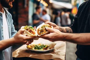 Deurstickers A chef gives a taco to a man at a street food market © pilipphoto