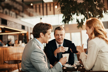 Diverse group of business friends having coffee after work in a café decorated for Christmas and the new year holidays