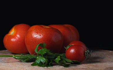 Red tomatoes on a dark background on the table