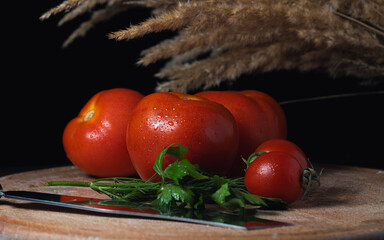 Red tomatoes on a dark background on the table