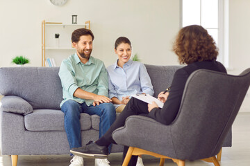 Happy family couple visiting professional therapist. Smiling husband and wife having psychotherapy session. Married man and woman go to therapy and notice significant improvement in their relationship - obrazy, fototapety, plakaty