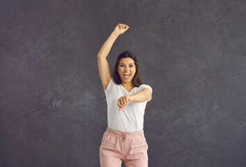 Portrait of happy young woman having fun feeling euphoric and celebrating success. Excited woman...