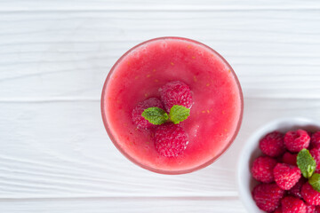 Raspberry smoothie red colorful fruit juice milkshake blend beverage healthy high protein the taste yummy In glass drink episode morning on white wood background from top view.