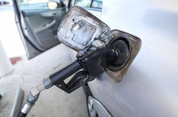 gas pump stands outside a hospital, representing rising fuel costs impacting healthcare budgets,...