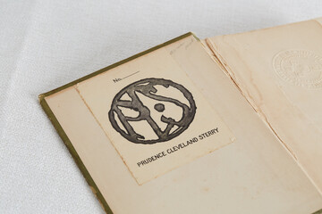 Open vintage book. Aged blank endpaper with a library stamp.
