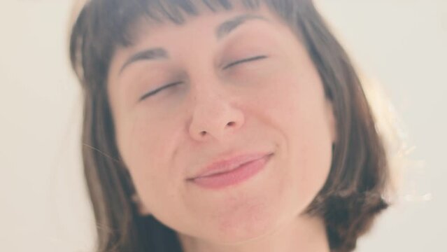 Close-up of a carefree laughing young woman. Portrait of a smiling woman with closed eyes enjoying life. Beautiful girl laughs.