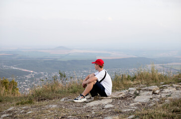 Fototapeta na wymiar teenage boy walking on the mountain in the evening in summer