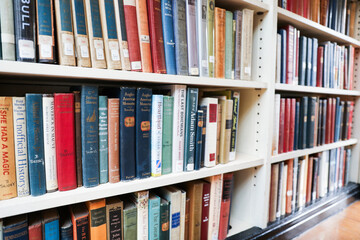 old books on wooden shelf in dimly lit library, vintage atmosphere, knowledge and learning concept