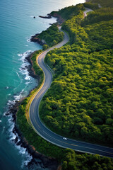 Aerial view of a road winding through green trees near the ocean. Generative AI