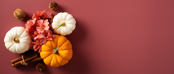Autumn banner with pumpkins and fall decor on brown background. Top view with copy space.