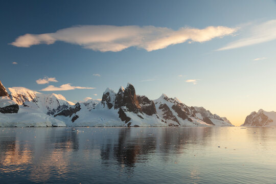Fototapeta Reflections of cliffs and mountains in the Lemaire Channel at sunset  Antarctica