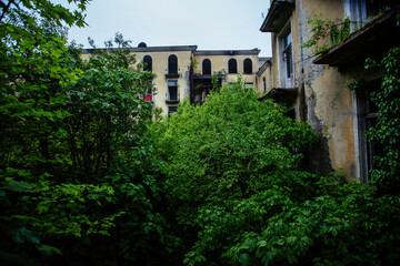 Fototapeta na wymiar Old ruins of Soviet Ghost town overgrown by vegetation