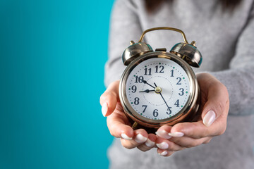 Woman holding an alarm clock in her hand
