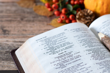 Open holy bible book and autumn fruit and leaves in the background. Christian thanksgiving and gratitude to God Jesus Christ, biblical concept.