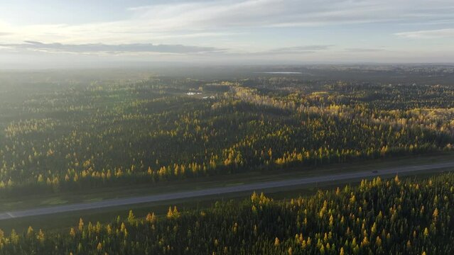 Alaskan Highway - Aerial drone video of lone vehicle driving along single two lane highway through the vast wilderness of northern British Columbia, Canada 
