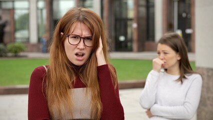 Young couple of lesbian women are arguing, quarreling outdoors. Problems in LGBT relationships.