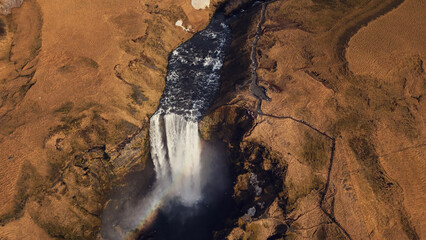 Aerial view of huge cascade in iceland, river flow running down from natural frozen hills....