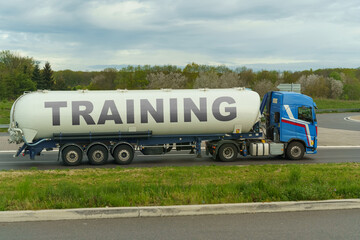 On a tank truck driving along the road there is an inscription - TRAINING