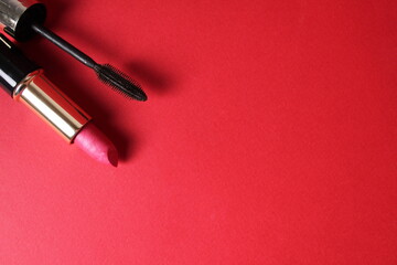 Make-up lipstick and mascara on a red background with space for text and copy space. Beauty salon...