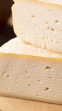 Vertical video. Artisanal Canastra cheese from Minas Gerais, Brazil over wooden board