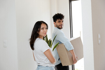 Hispanic couple moving - young couple leaving their house with moving boxes