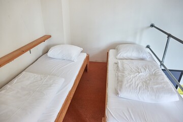 Dormitory room with simple beds - obrazy, fototapety, plakaty