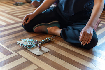 Person in lotus position with lavender and objects for a healing ceremony