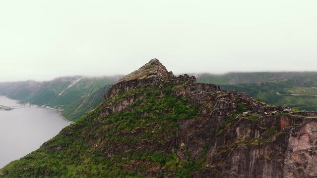 Aerial exploration - mossy mountain wall revealing Lofoten islands' rocky coastline.