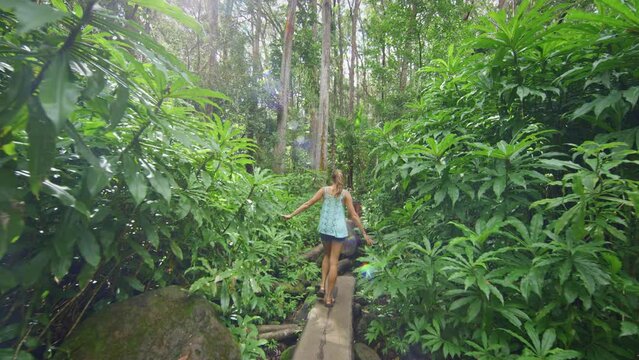 Walking across log balancing in jungle