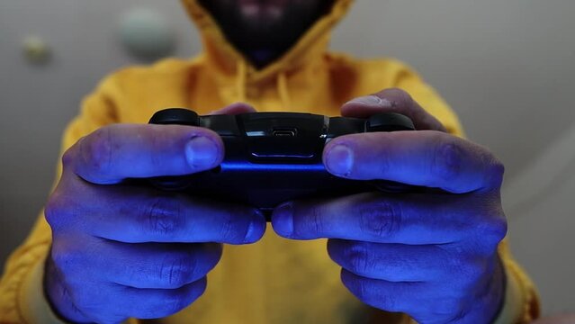 Man playing on a console with a gamepad.