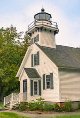 Fototapeta premium Historic Mission Point Lighthouse stands near Traverse City, Michigan at Lake Michigan. You see the tower and the front entrance. The old building stands at the 45th parallel.