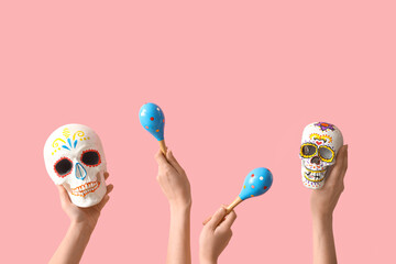 Female hands holding painted human skulls for Mexico's Day of the Dead (El Dia de Muertos) and...