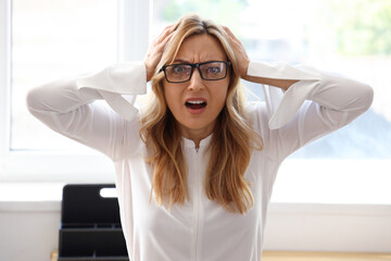 Scared mature businesswoman in office, closeup