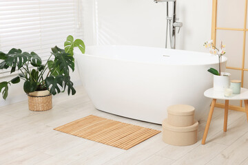 Stylish bathroom interior with bath tub, houseplants and bamboo mat - obrazy, fototapety, plakaty