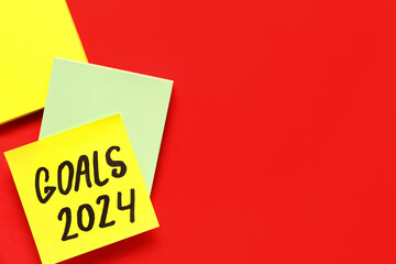 Sticky notes with goals for 2024 on red background