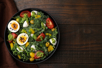 Delicious salad with pesto sauce in bowl on wooden table, top view. Space for text